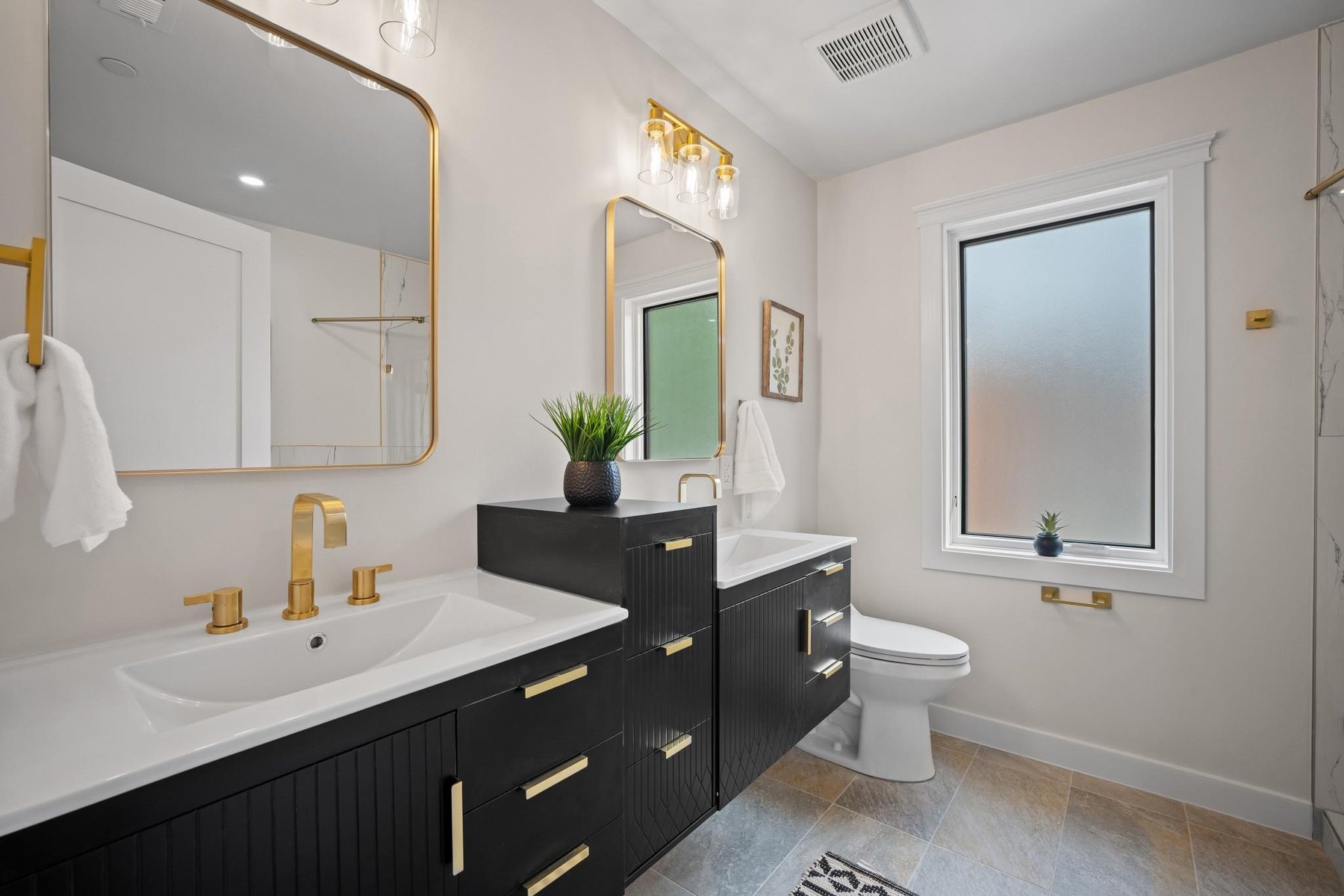 Renovated bathroom with black vanity and brass fixtures